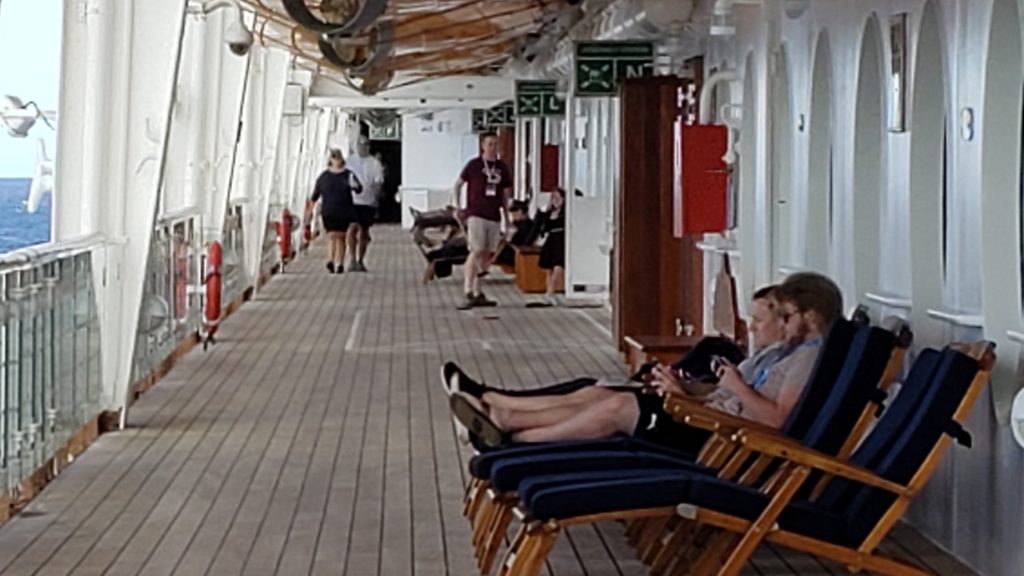 Empty Deck with adults playing on electronics